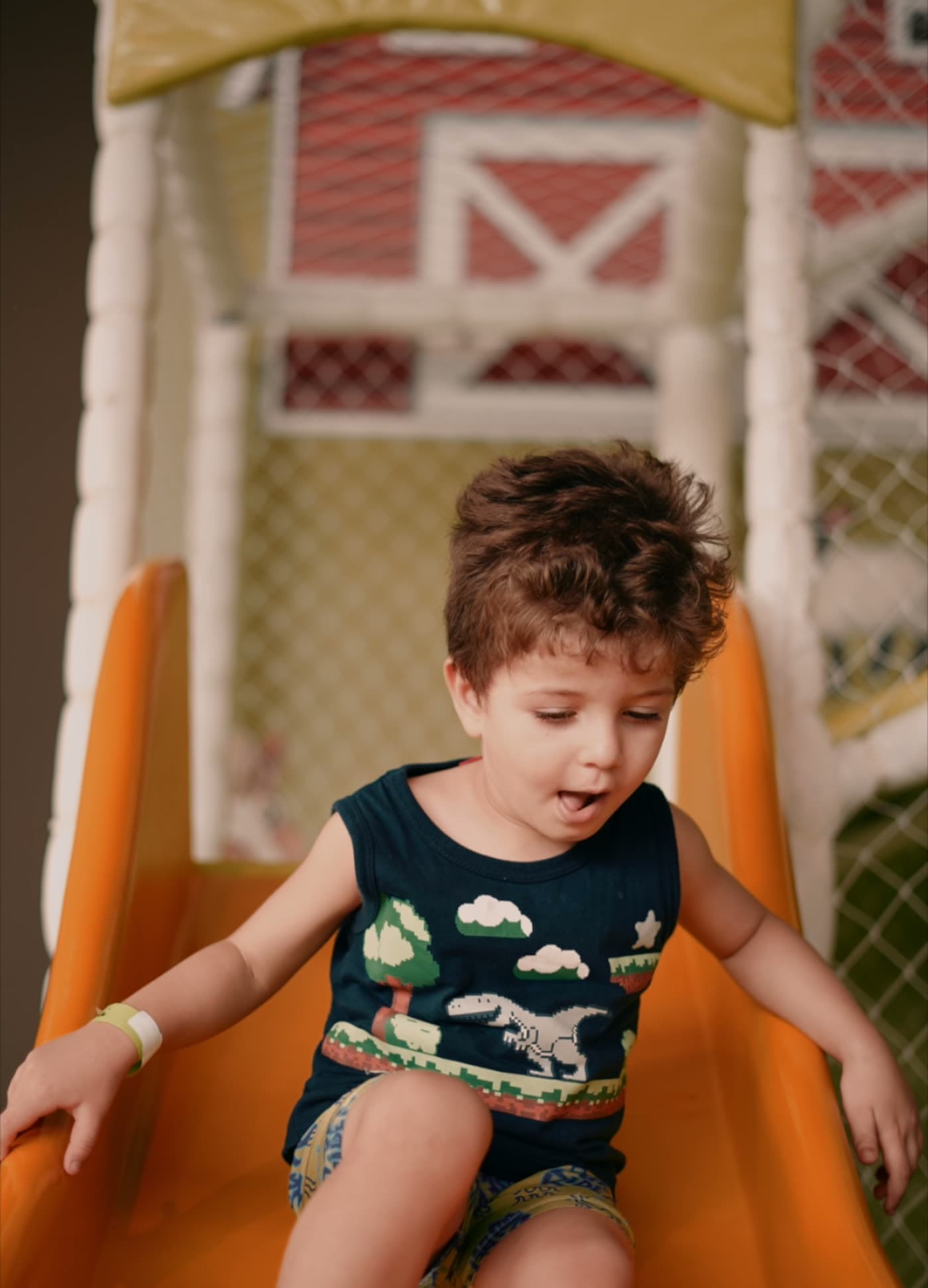Criança descendo o escorregador no Espaço Kids
